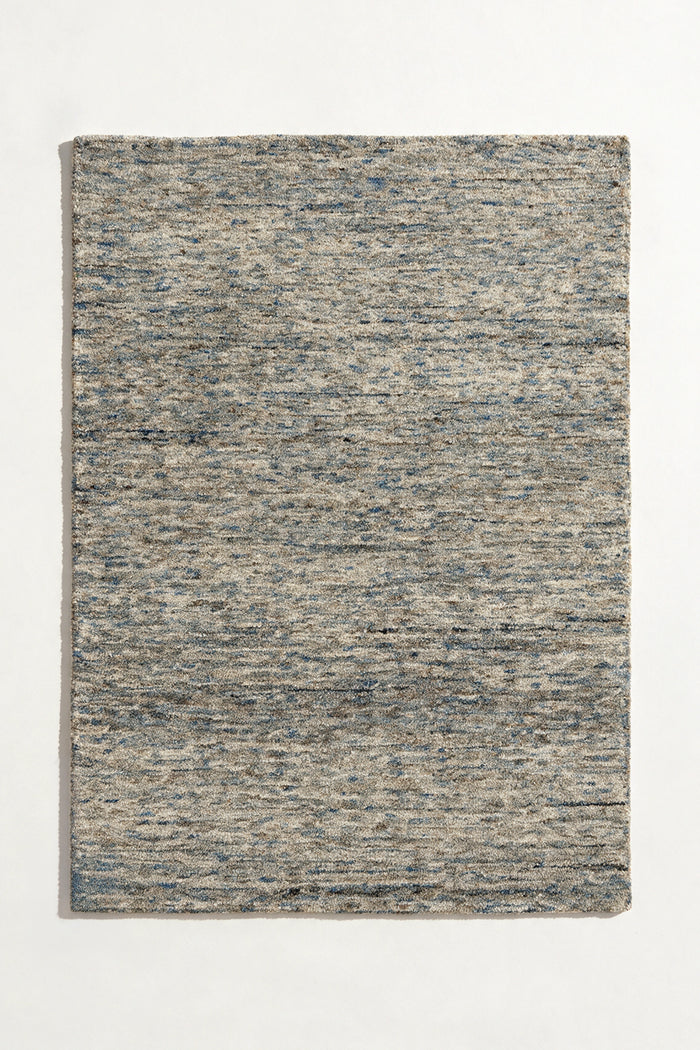 a flint hand-tufted wool rug with heathered grey, blue and sand flecks shown from above
