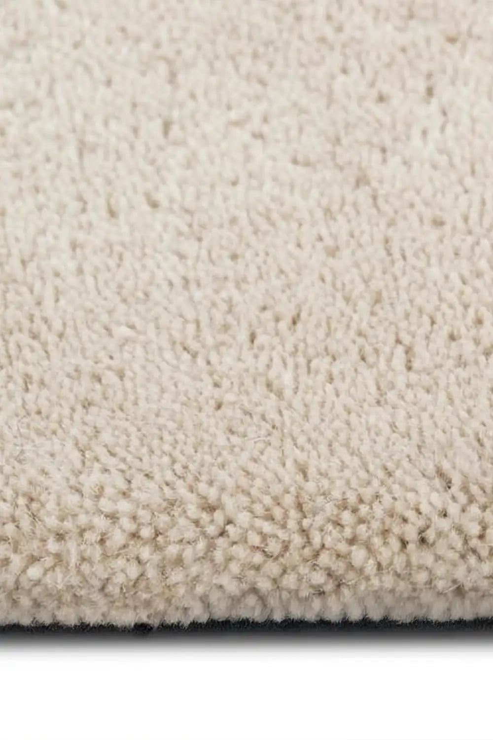 close up of hand tufted thick wool rug pile in off white oreo