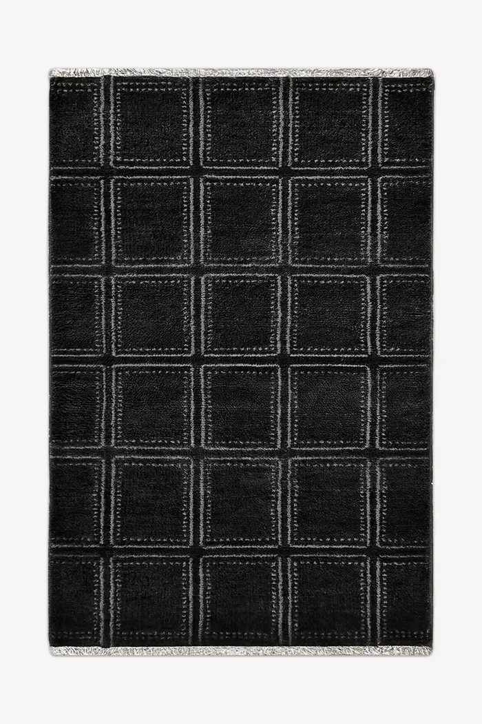 Black checkered wool rug with white lines on a white background