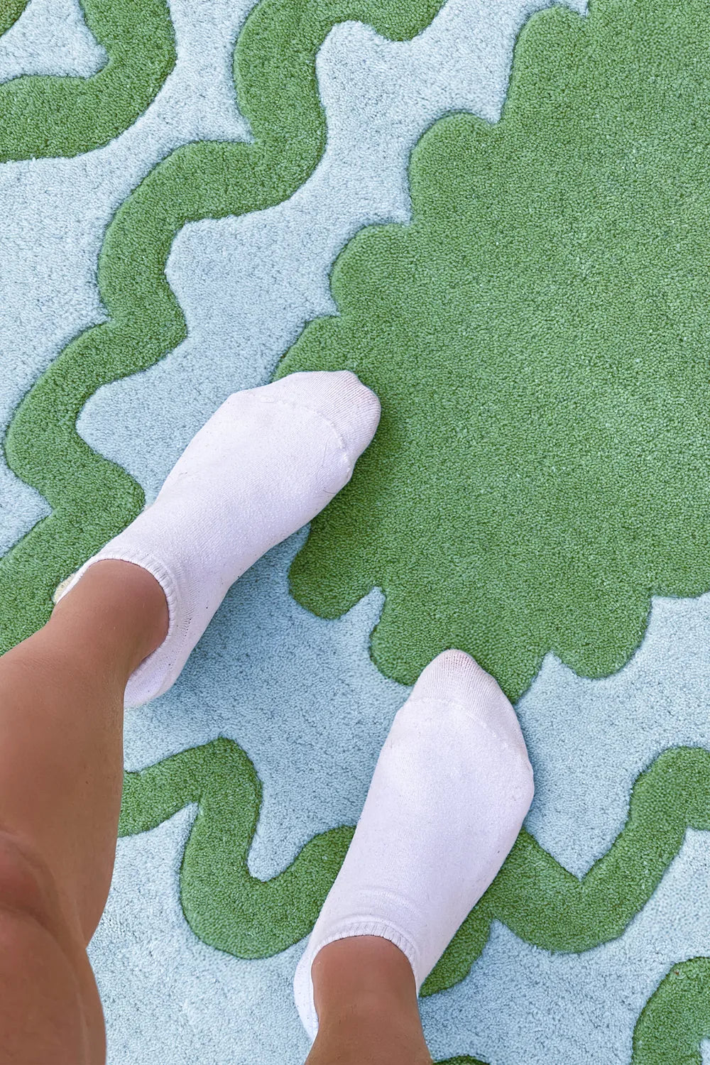 Close-up of green and blue wavy rug with soft texture, showcasing plush feel underfoot, perfect for cozy modern spaces lifestyle