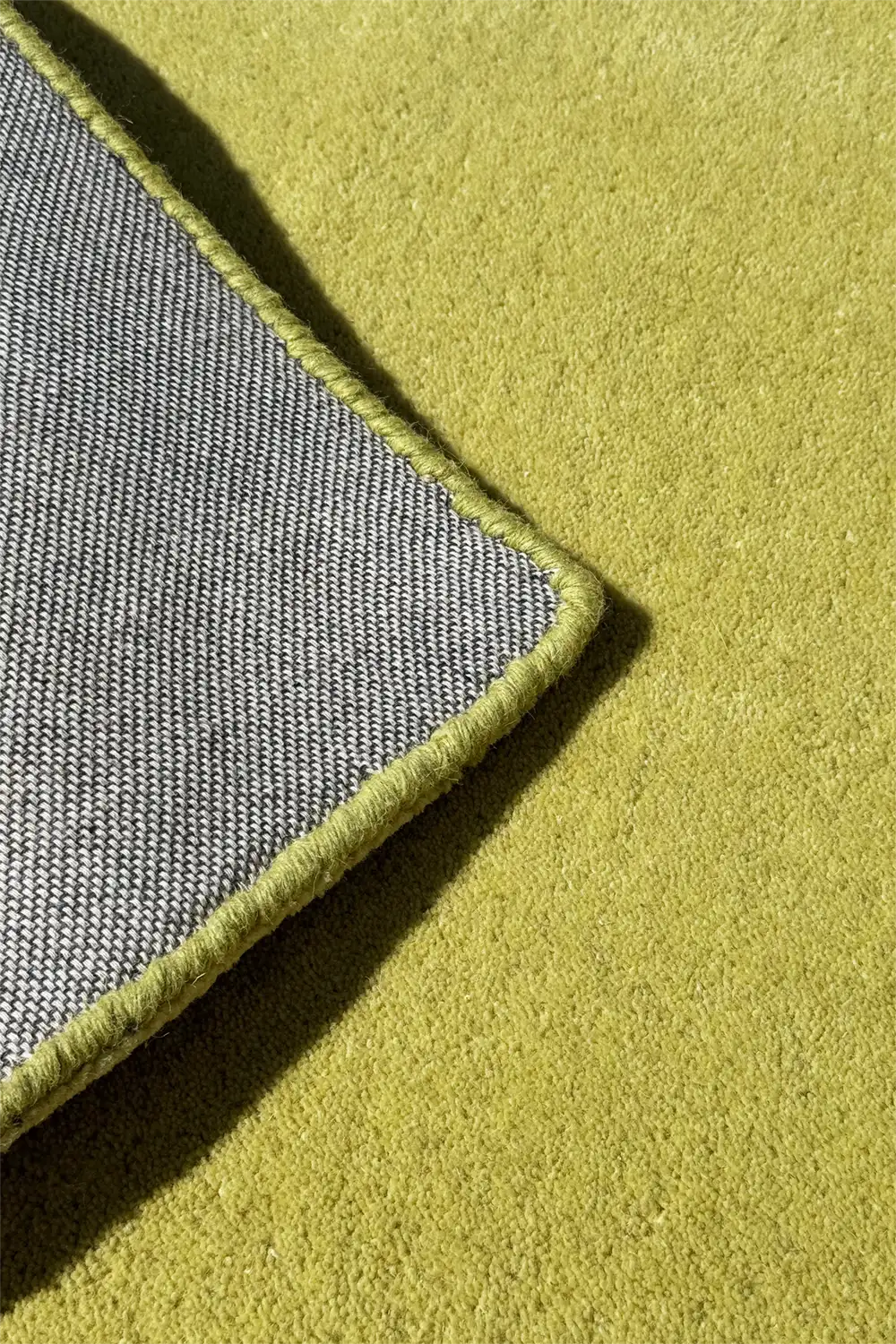 Close-up of a light neon green rug with durable cotton backing