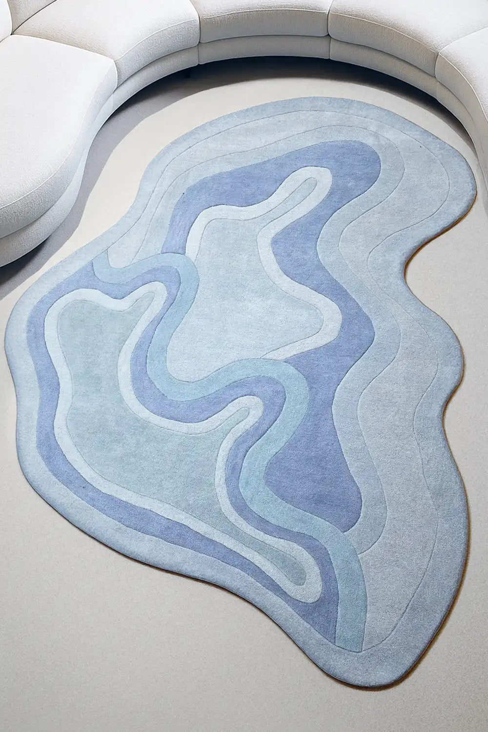 Sculpted blue wool rug in a modern living room with light wood floors and organic curves lifestyle