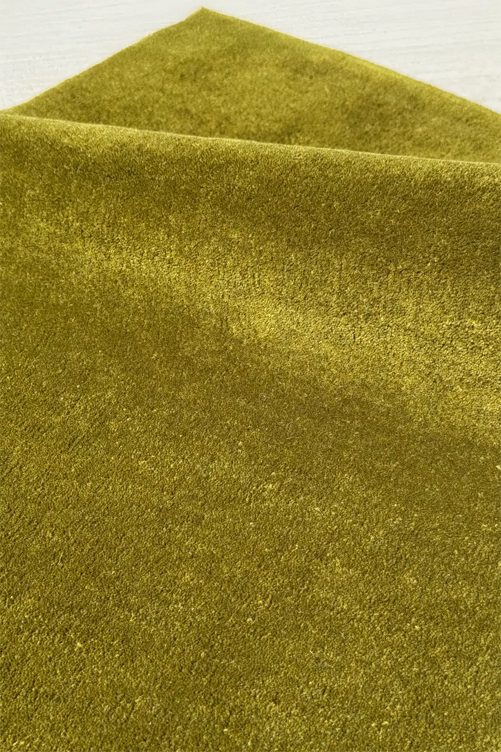 Close-up of green hand-tufted square rug texture