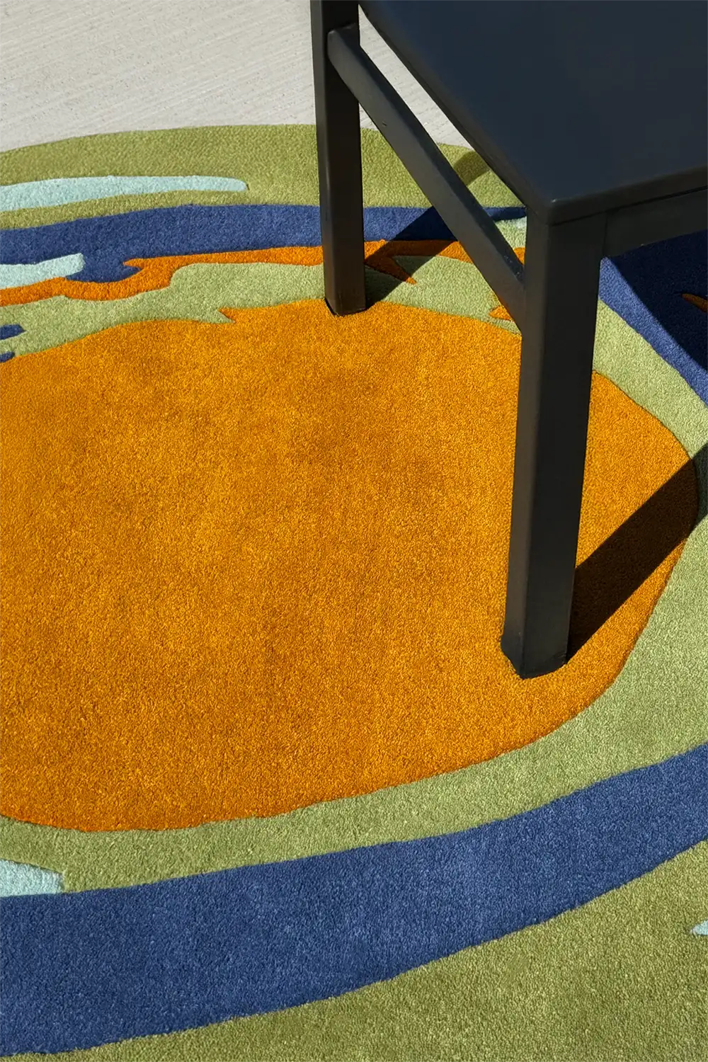 Oval living room rug with bright orange center and curved abstract border, ideal as a coastal or boutique rug lifestyle