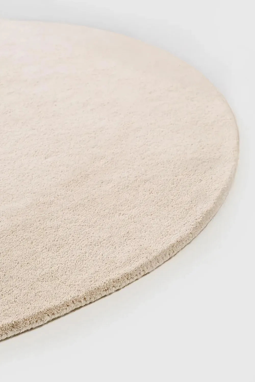 Detail of thick cream wool round rug edge, designed for modern and japandi interiors