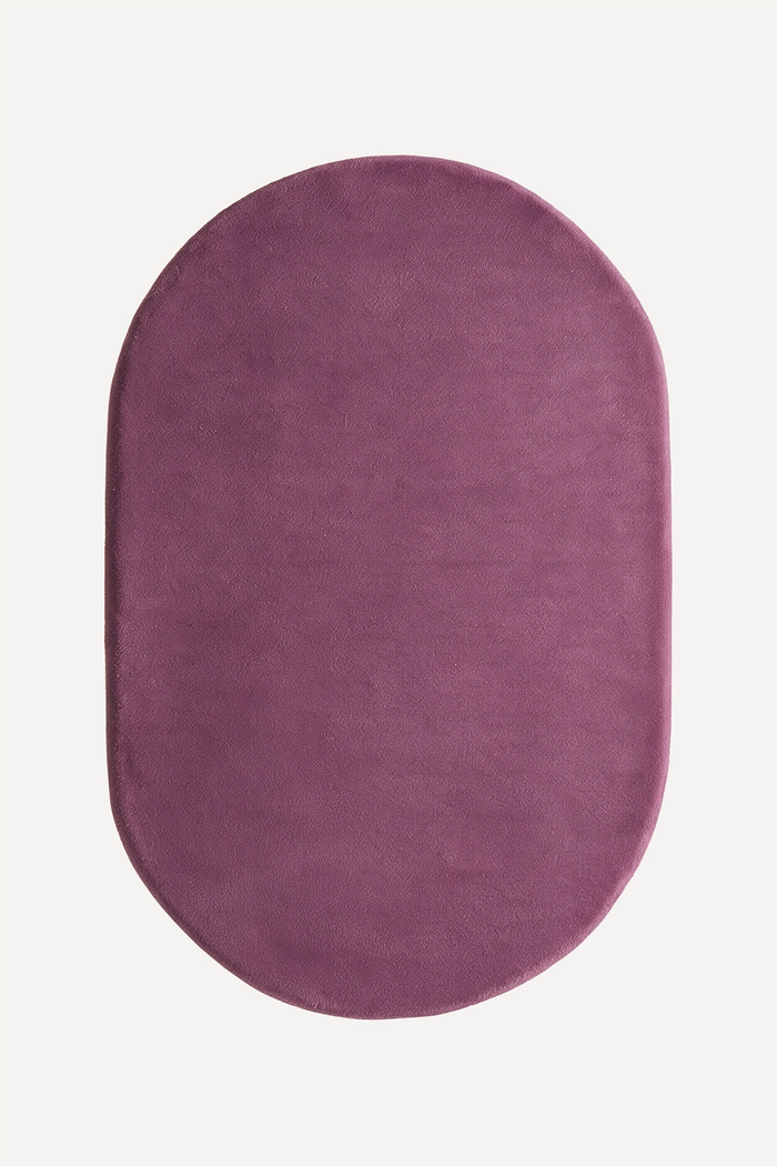 Oval-shaped purple plum rug on a white background
