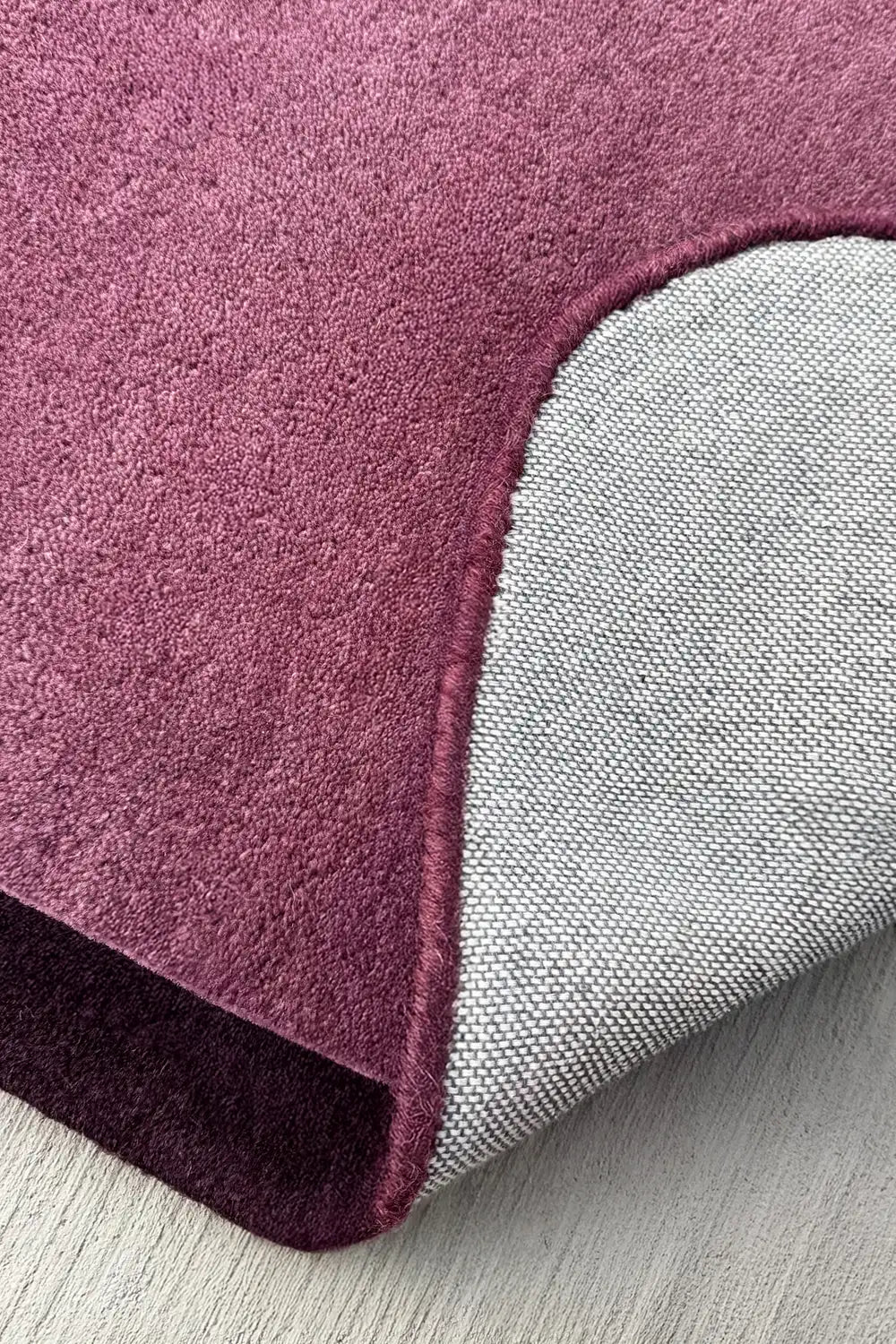 Hand-tufted soft purple wool rug with sculptural corner finish, ideal for bedrooms and living rooms