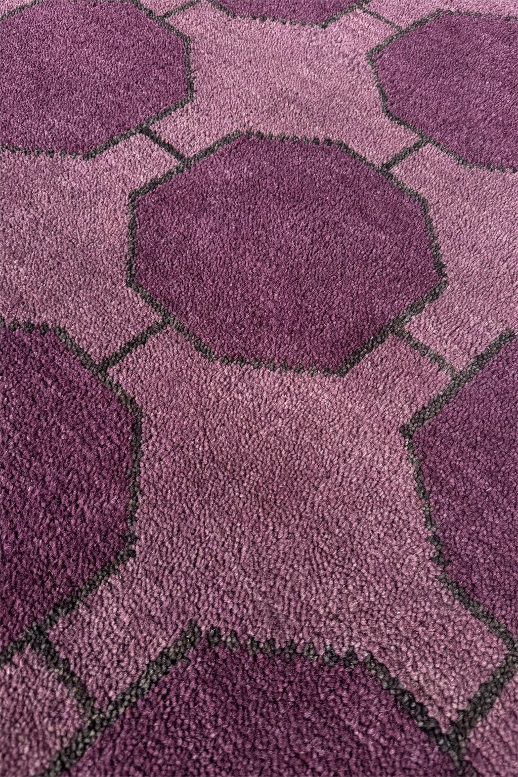 Close-up of a purple wool rug texture with geometric pattern