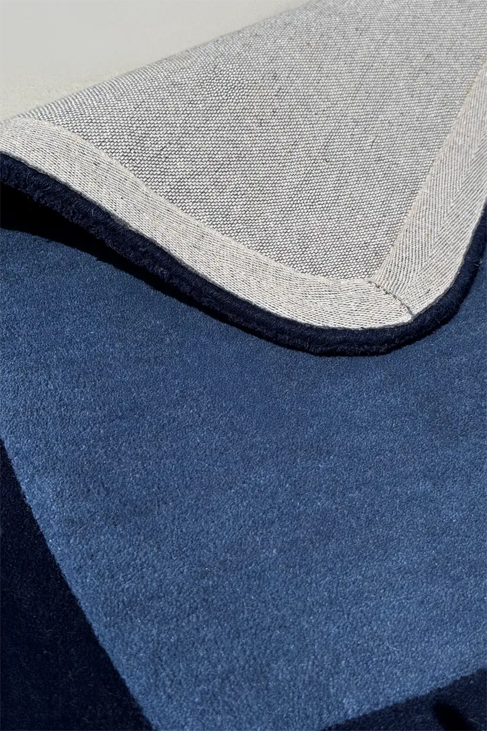 close up texture of blue and navy modern tufted wool area rug with contemporary curved edges