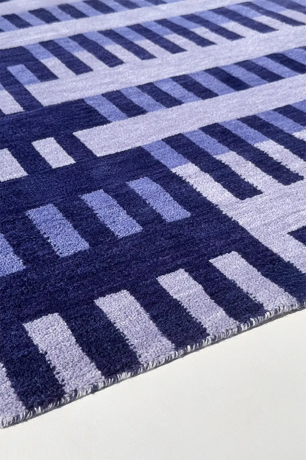 Close-up of a light blue and navy striped modern geometric patterned rug