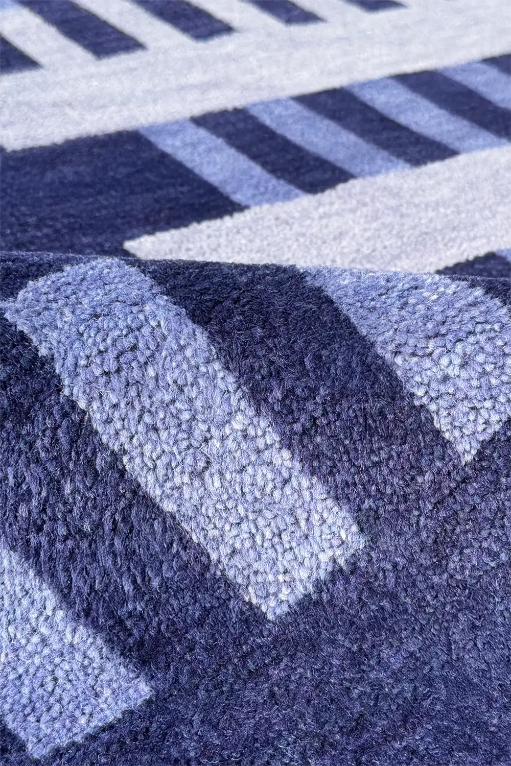 Close-up of a blue and navy geometric patterned wool handmade rug