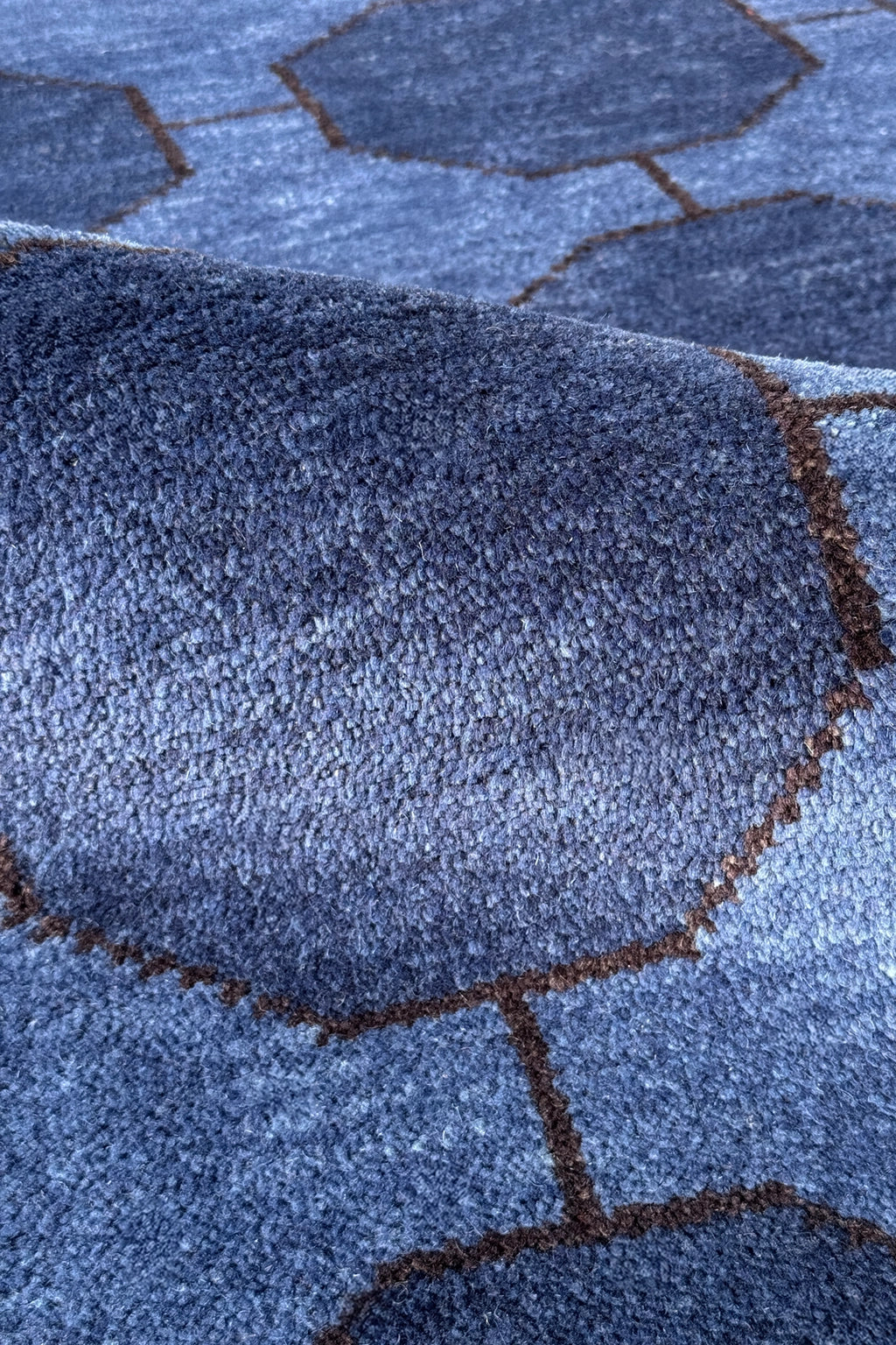 Close-up of a blue textured rug with geometric patterns