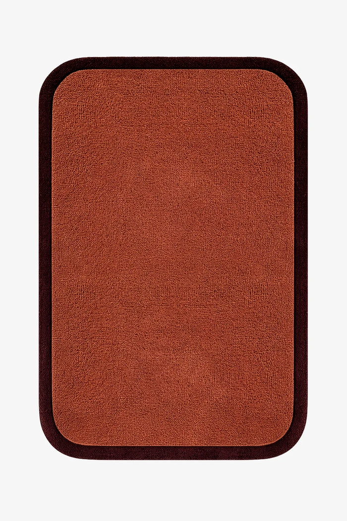 modern brown rug with a dark border on a white background hand-tufted wool