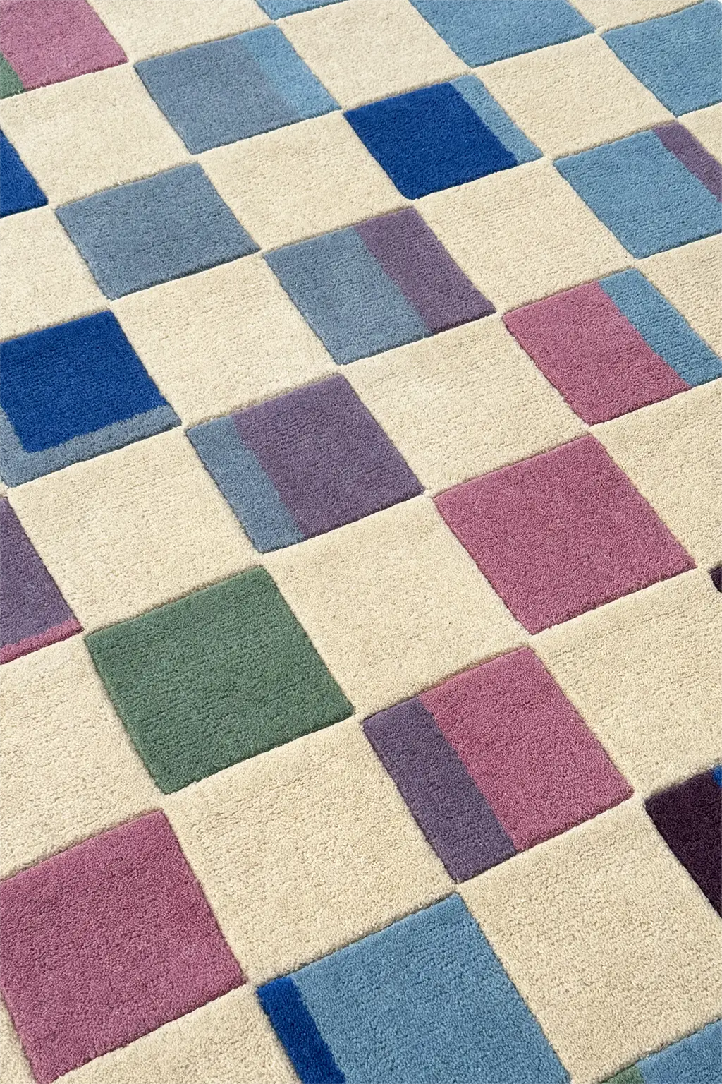 Patterned rug with square tiles in blue, purple, and green on a beige background