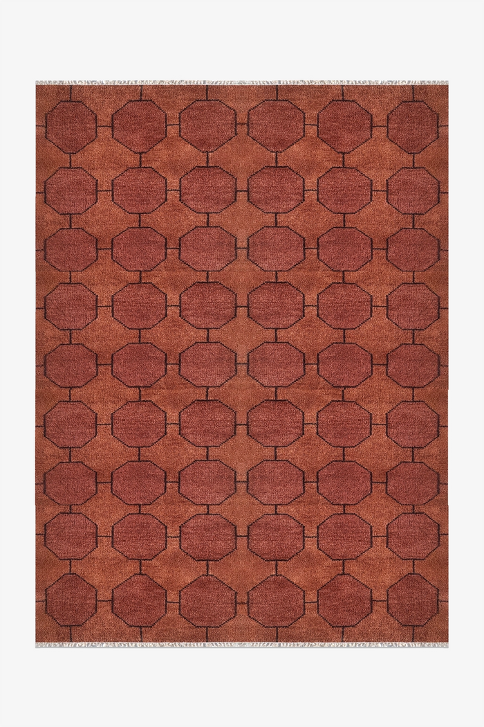warm brown geometric patterned rug on a white background