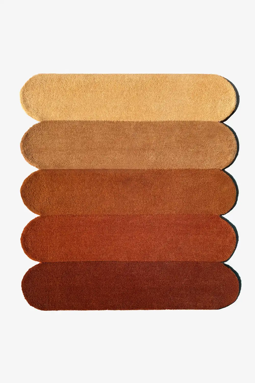 Modern 9x12 scalloped area rug in warm terracotta and burnt orange tones, perfect for mid-century or boho interiors