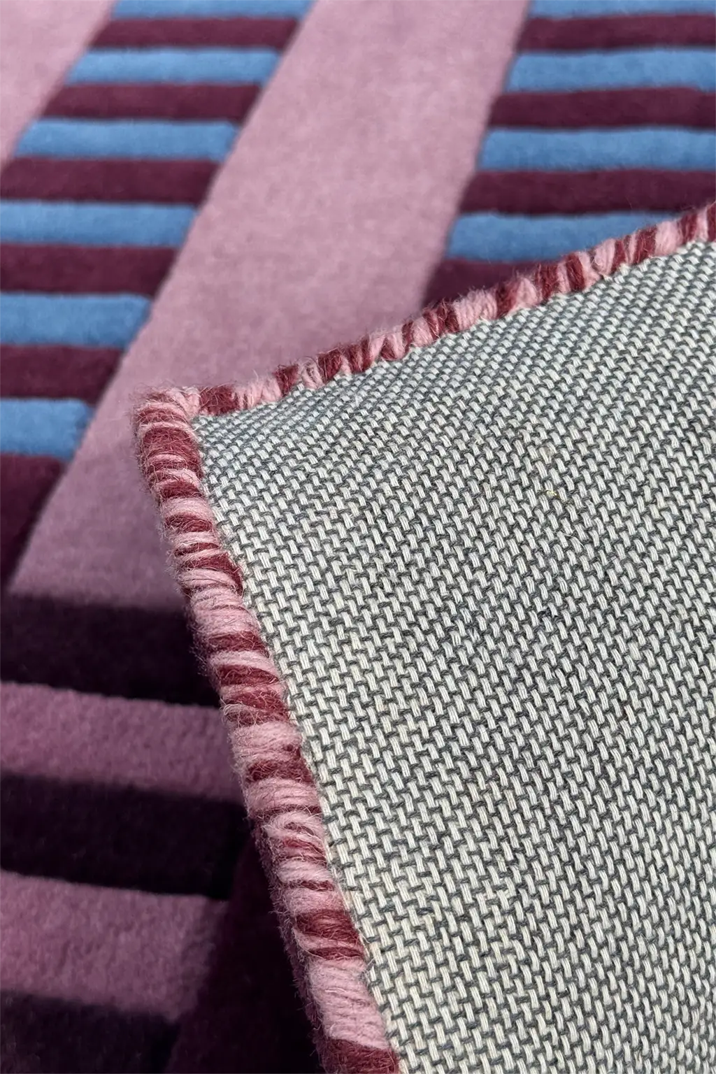 Close-up of tufted wool rug with striped pattern and textured surface