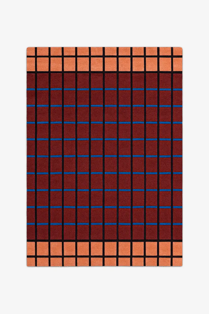 Plaid patterned rug with red, blue, and orange colors on a white background