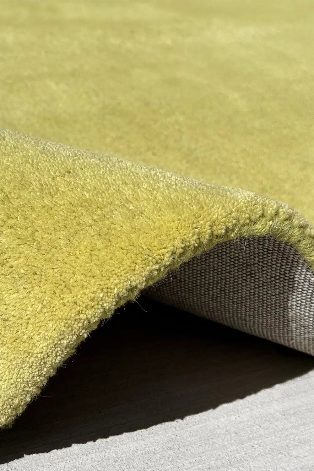 close-up of light olive green wool tufted area rug with thick surface