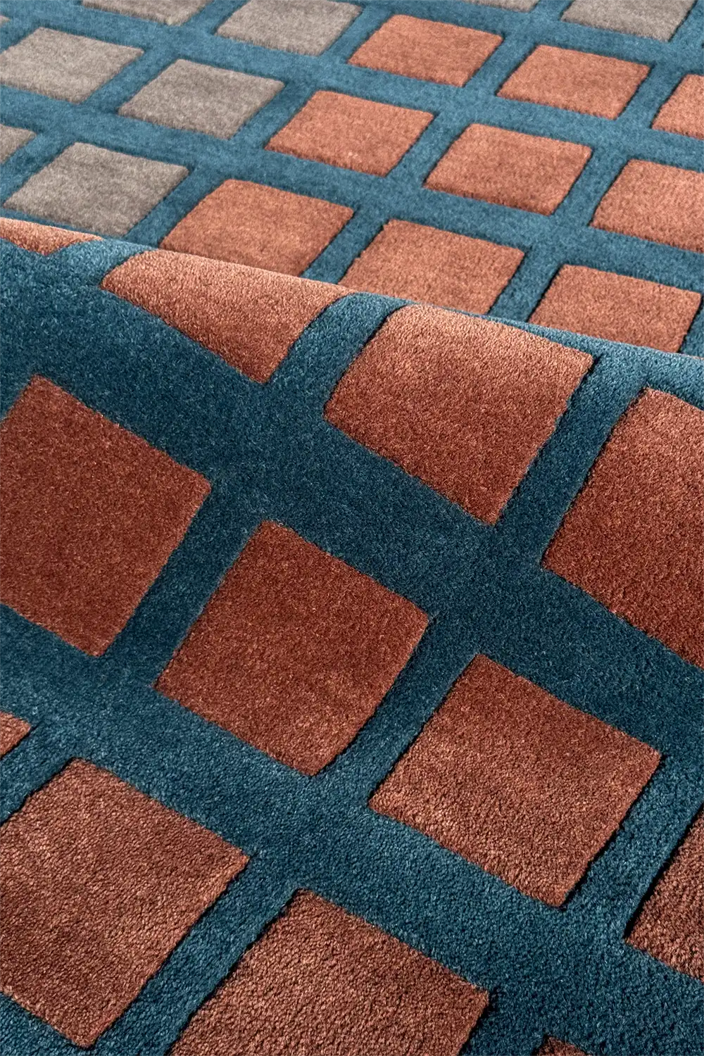 Close-up of a textured rug with brown and blue square patterns