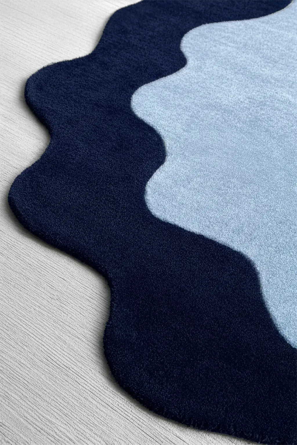 Navy and light blue scalloped rug on a gray floor