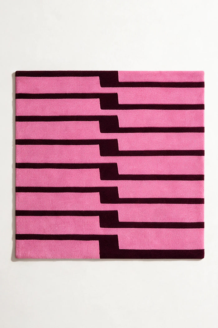 Pink striped square rug hand-tufted in wool on a white background
