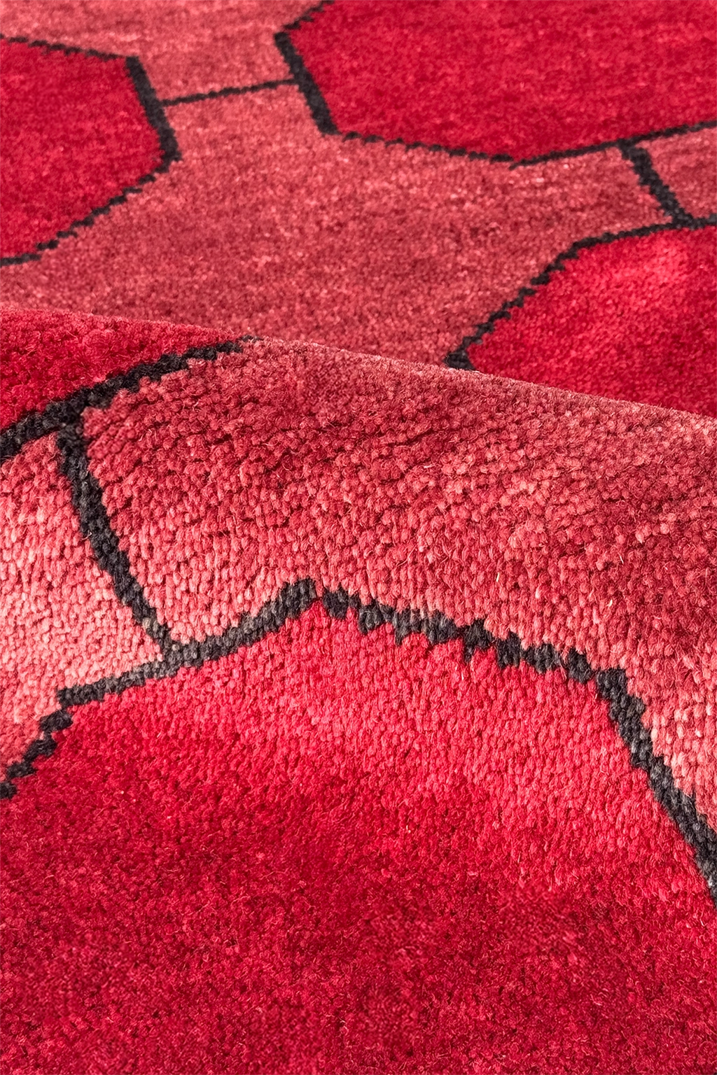 Close-up of a red geometric patterned rug with black accents