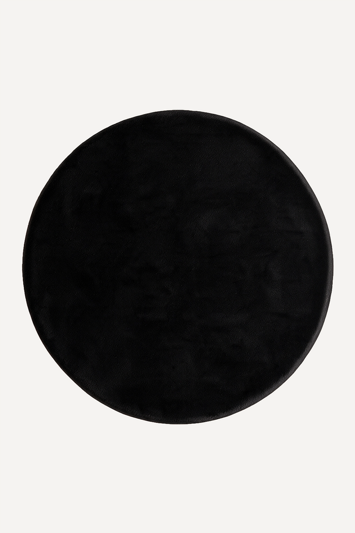solid black round rug on a white background