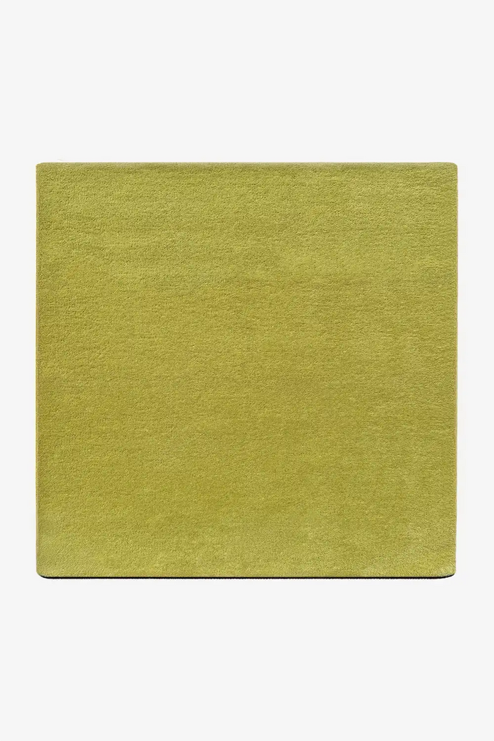 Solid lime green square wool area rug on a white background