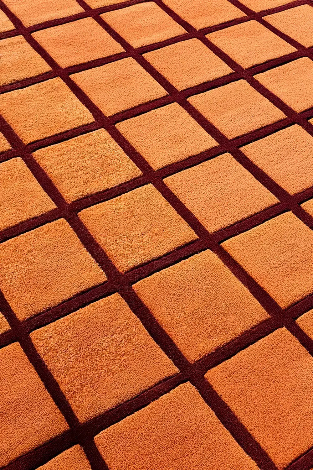 orange and burgundy grid pattern square hand tufted wool rug
