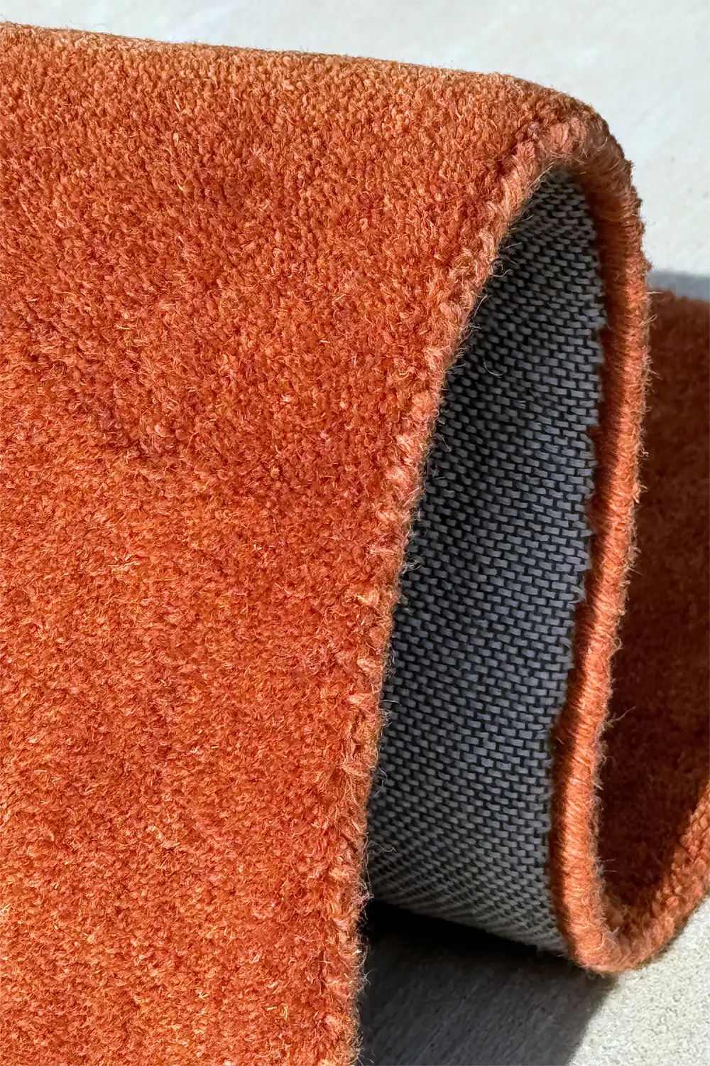 High pile tufted wool rug in warm earthy tones with sculpted silhouette and soft finish