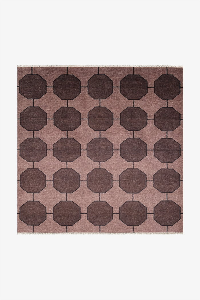 dark brown square rug with geometric pattern on a plain background