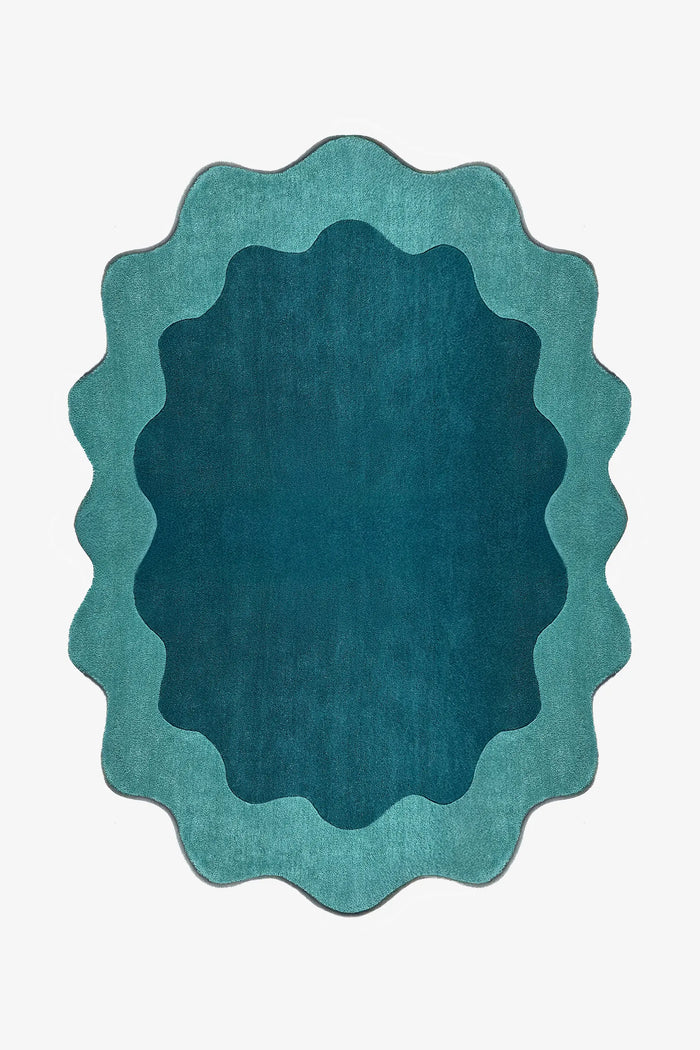 Teal and turquoise scalloped edge rug with abstract curved silhouette, a bold 8x10 oval area rug for living rooms or bedrooms