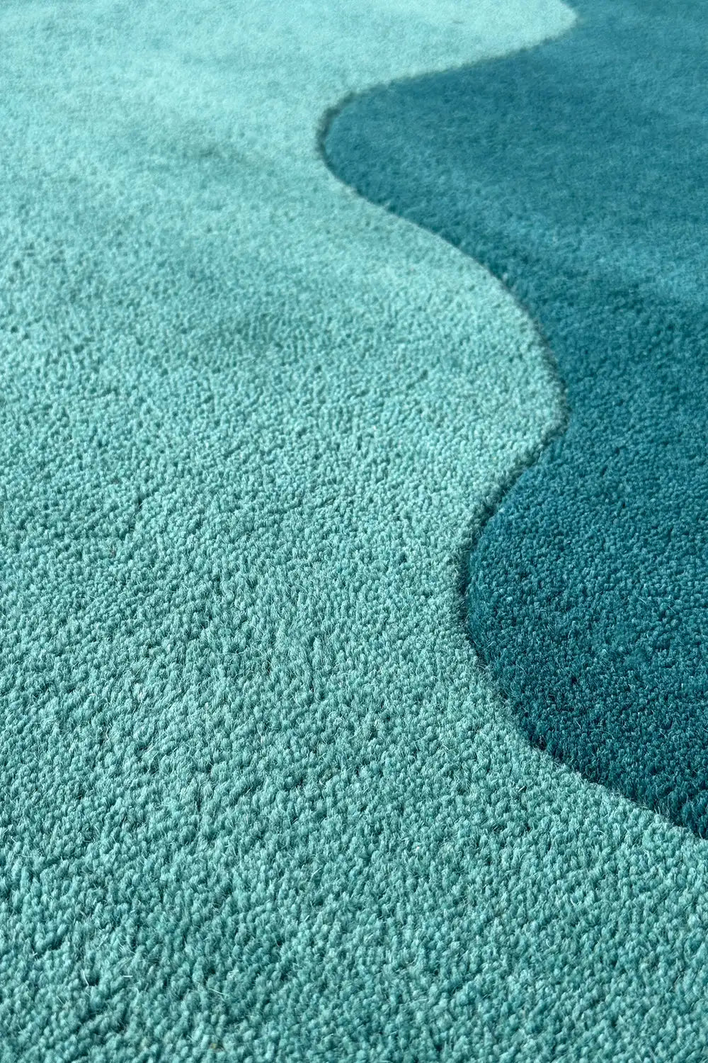Seamless transition from teal to turquoise in a funky wavy edge rug, ideal as a round boho rug or colorful rug for the living room