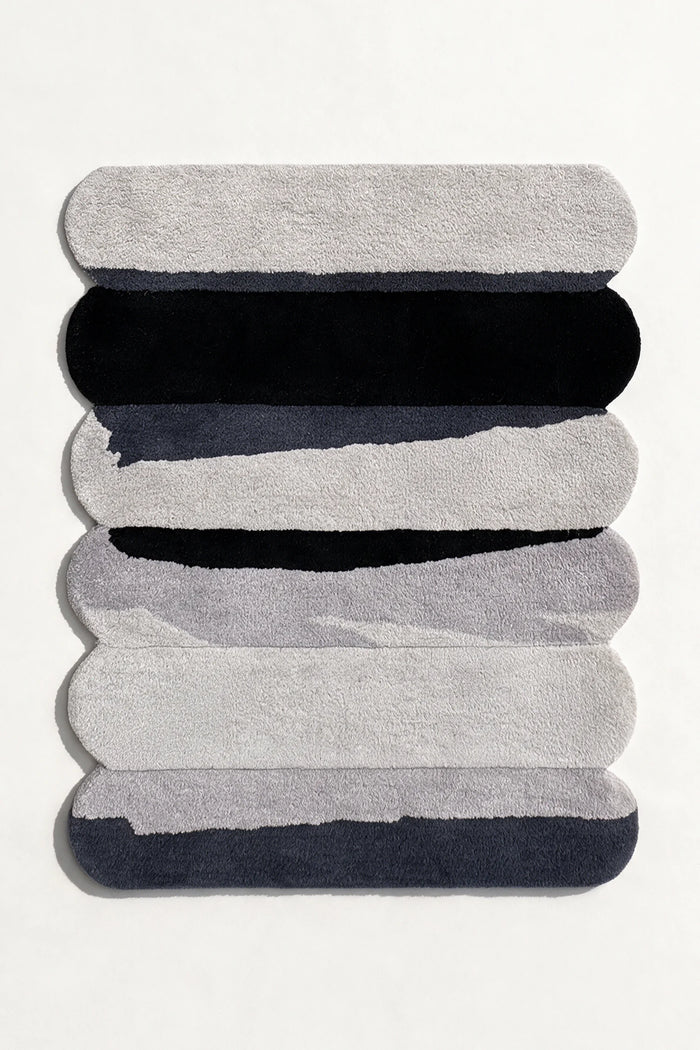 silver gray rug with scalloped edges and contemporary black stripe design