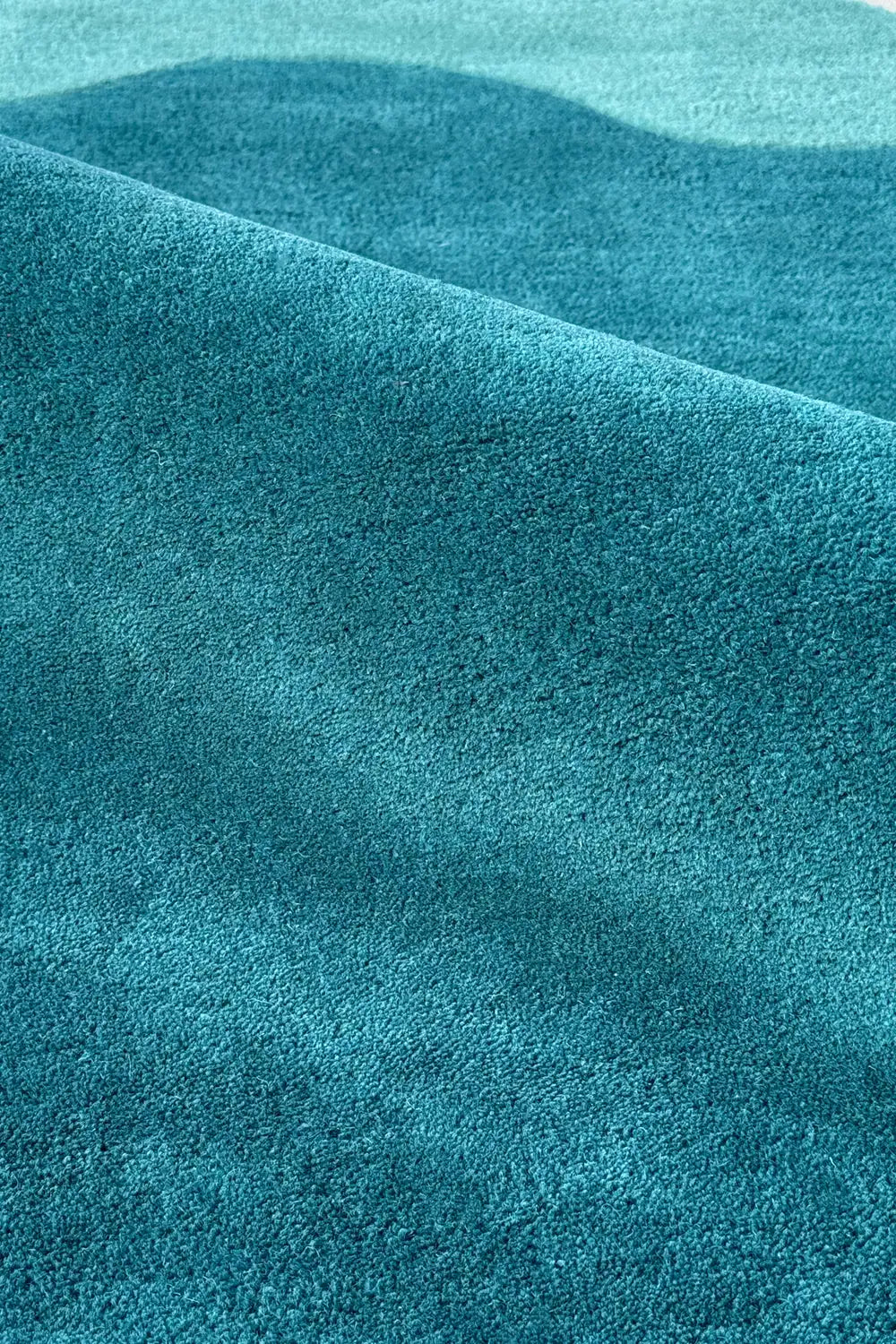 Close-up of plush deep teal wool pile, ideal as a colorful round rug or modern teal carpet for fun, artsy interiors