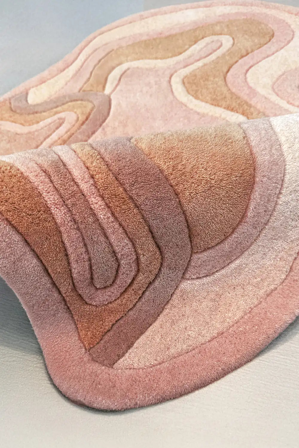 Hand-tufted wool rug in soft orange rust with raised flowing contours, cozy modern accent