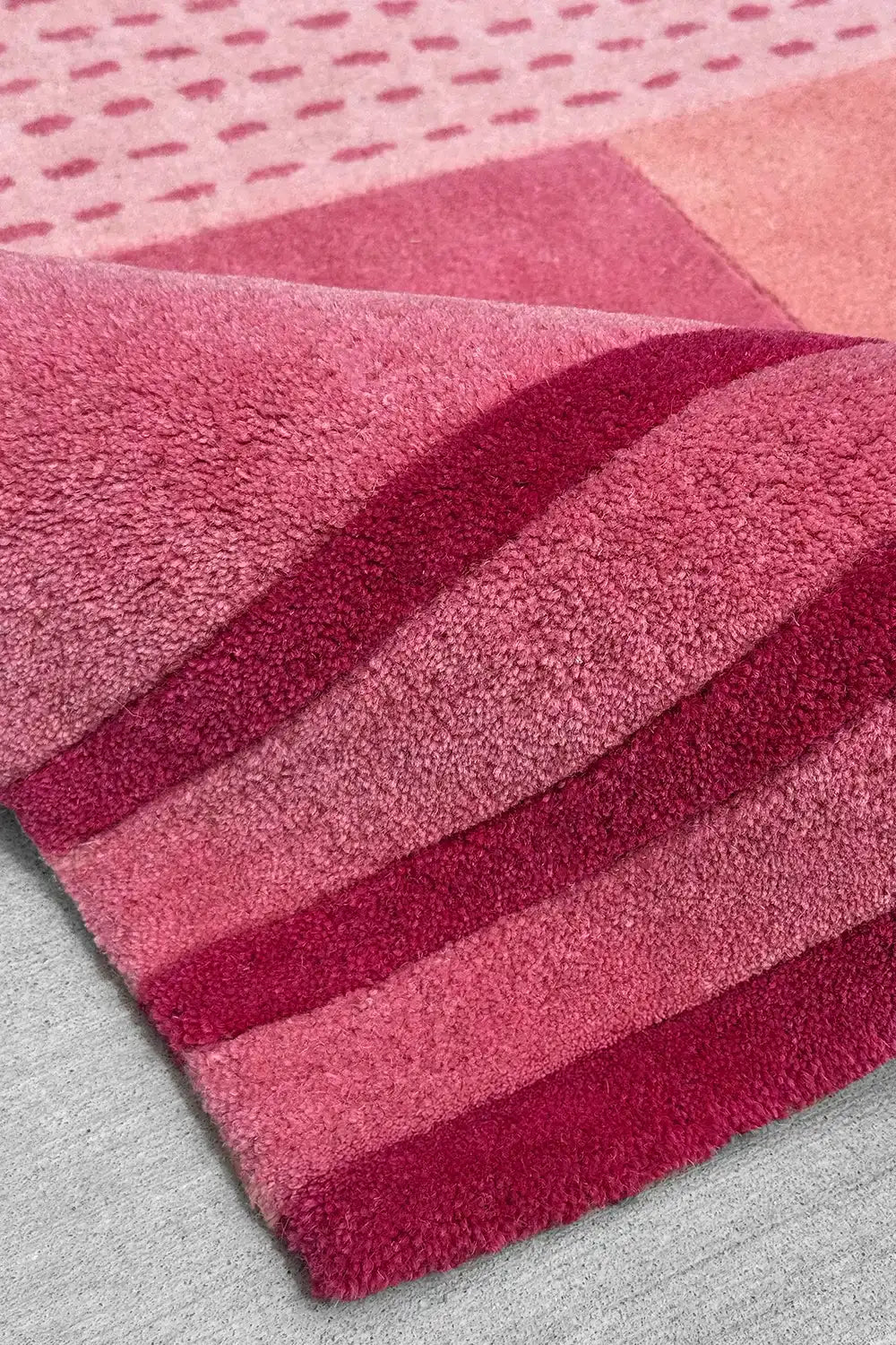 8x10 modern geometric pink area rug with tufted pile, sculptural stripes, and varied block tones