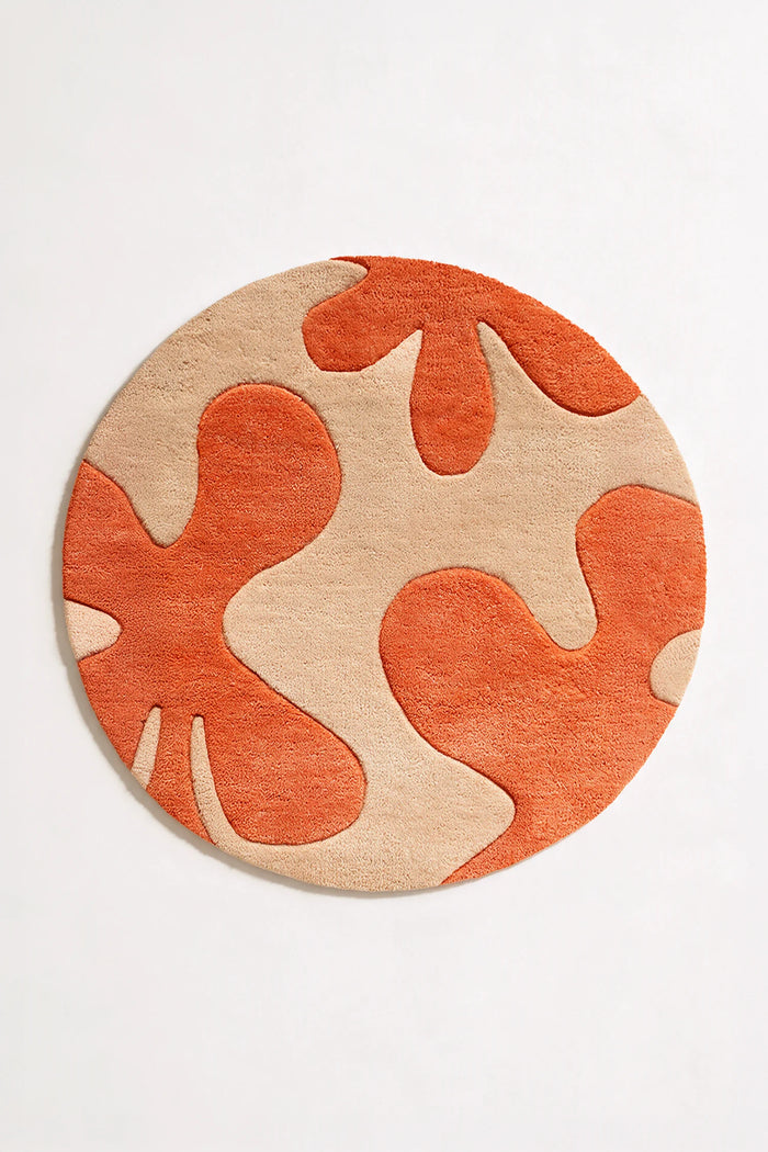 Hand-tufted modern round rug with orange and tan abstract floral pattern, wool 6ft rug