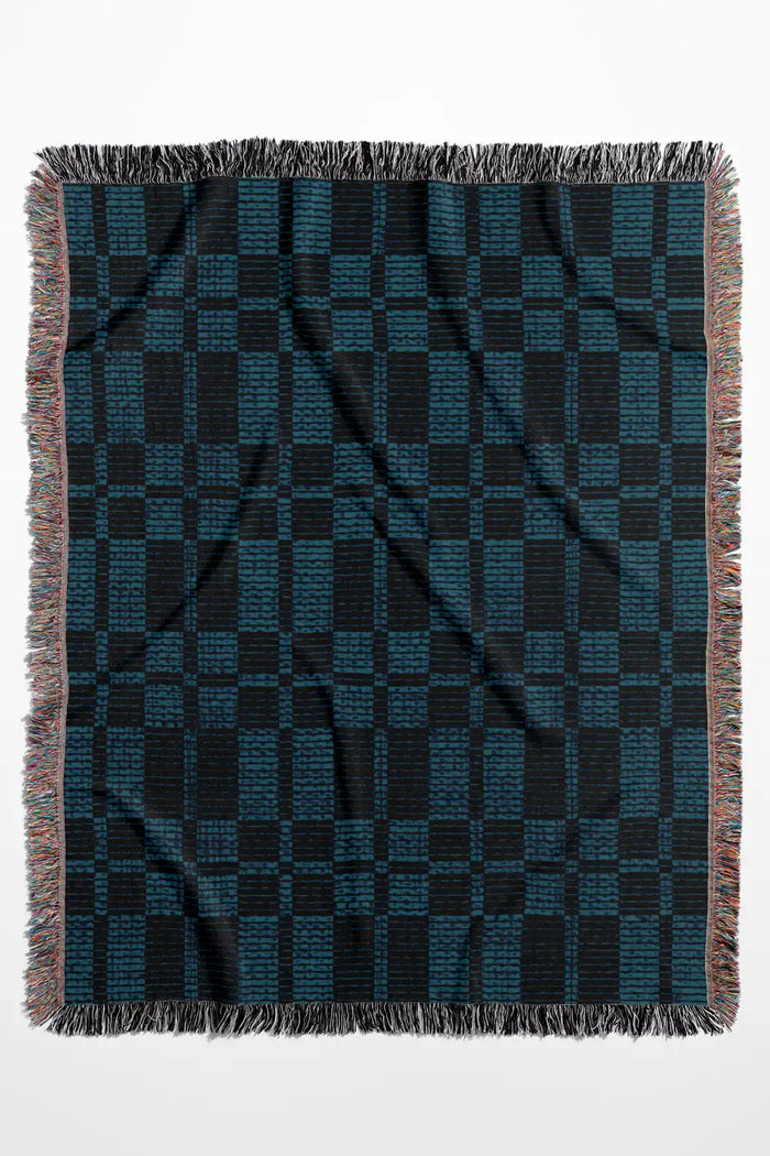 Blue and navy plaid woven throw blanket with fringe detailing.