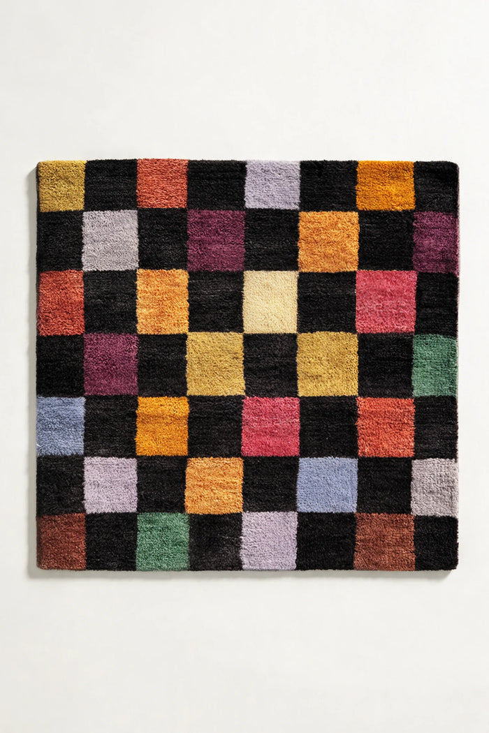 Colorful checkerboard wool rug in square shape, featuring black, yellow, green, and pink blocks, available in 8x8 and custom sizes