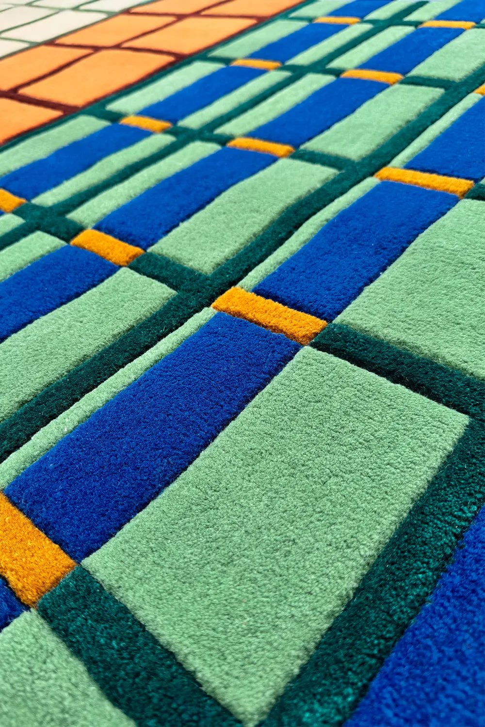5x7 modern graphic wool rug with colorful grid layout in primary tones and hand-tufted texture