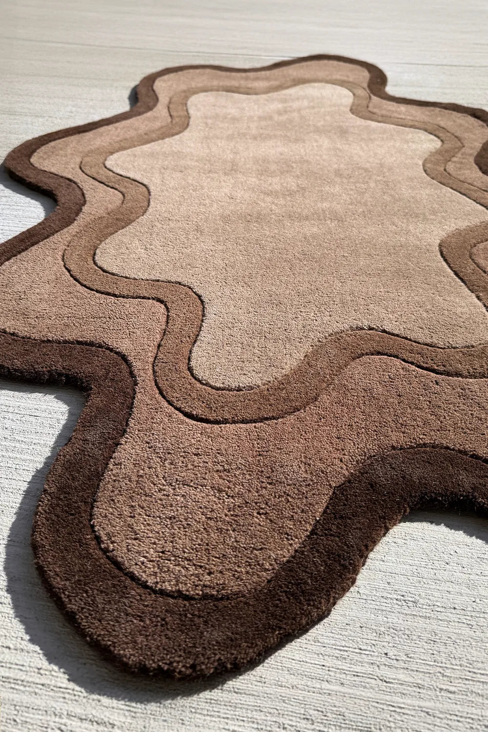 Modern abstract brown rug with irregular edges, a 6x9 organic shaped wool rug for contemporary living spaces
