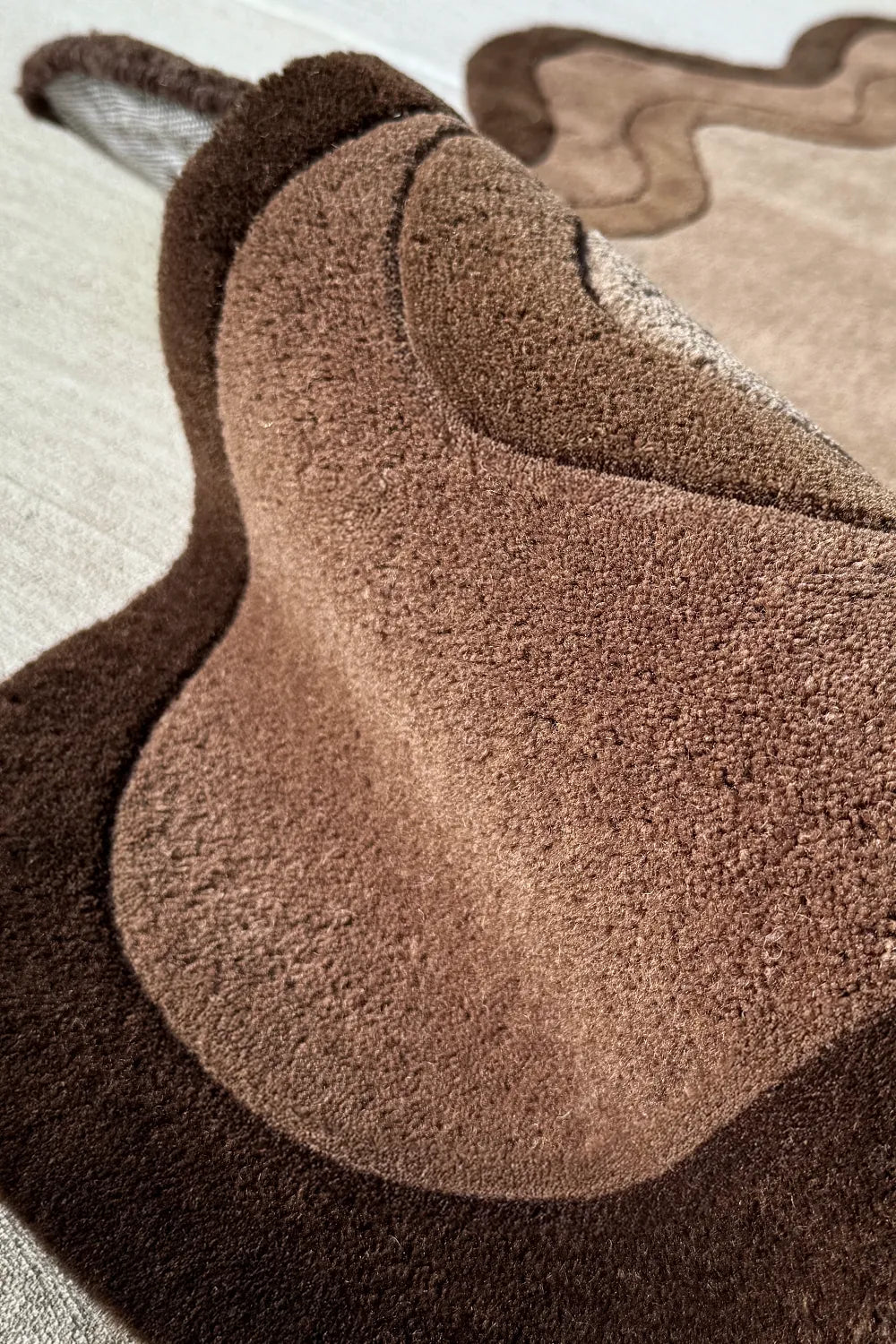 Texture closeup of a dark neutral irregular area rugs with modern organic design for living room and bedroom decor