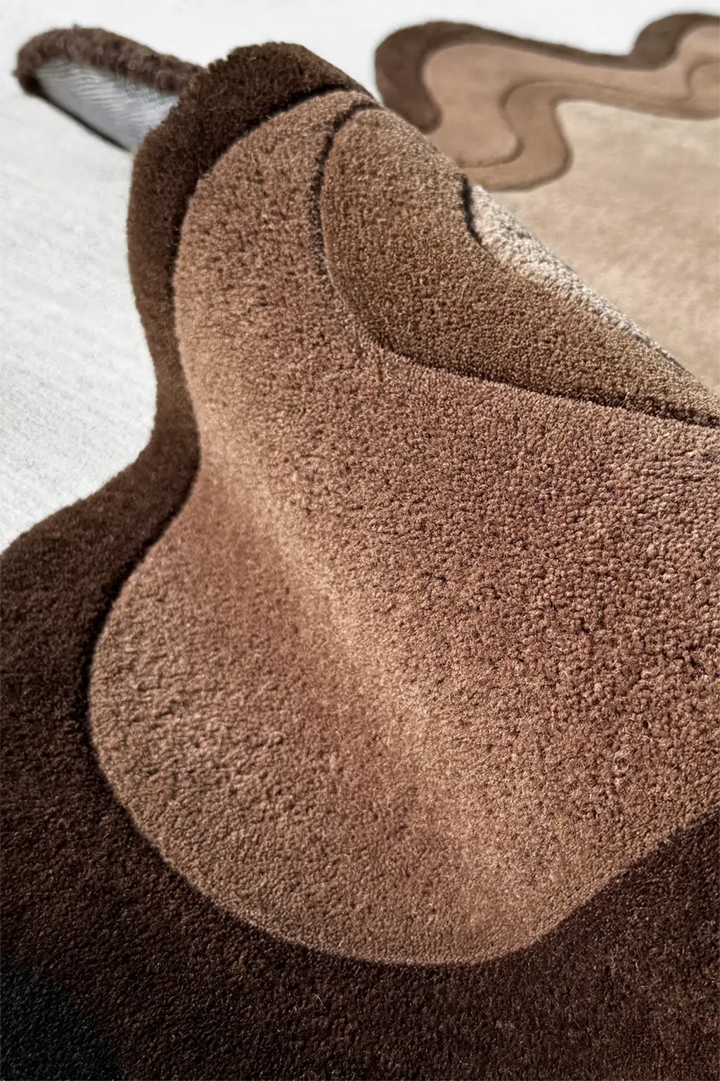 Texture closeup of a dark neutral irregular area rugs with modern organic design for living room and bedroom decor