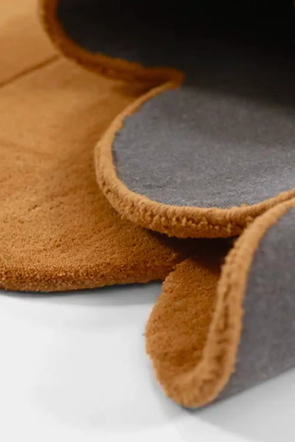 Detail of thick gold wool modern area rug with a soft rounded edge