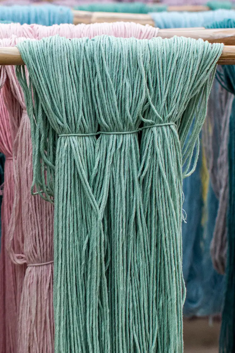 Freshly dyed teal wool hanging to dry for use in custom wool rugs