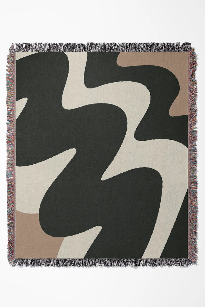 High-contrast cotton woven throw blanket featuring fluid shapes in black, off-white, and beige.