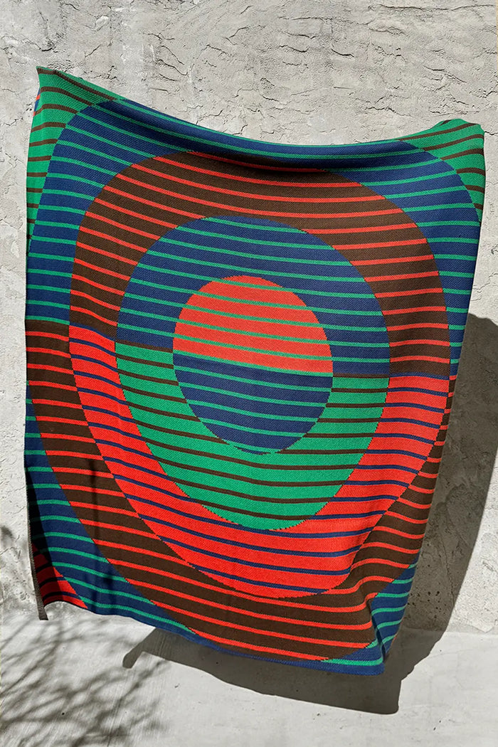 Colorful knit throw blanket by Jubi with a modern geometric striped pattern.
