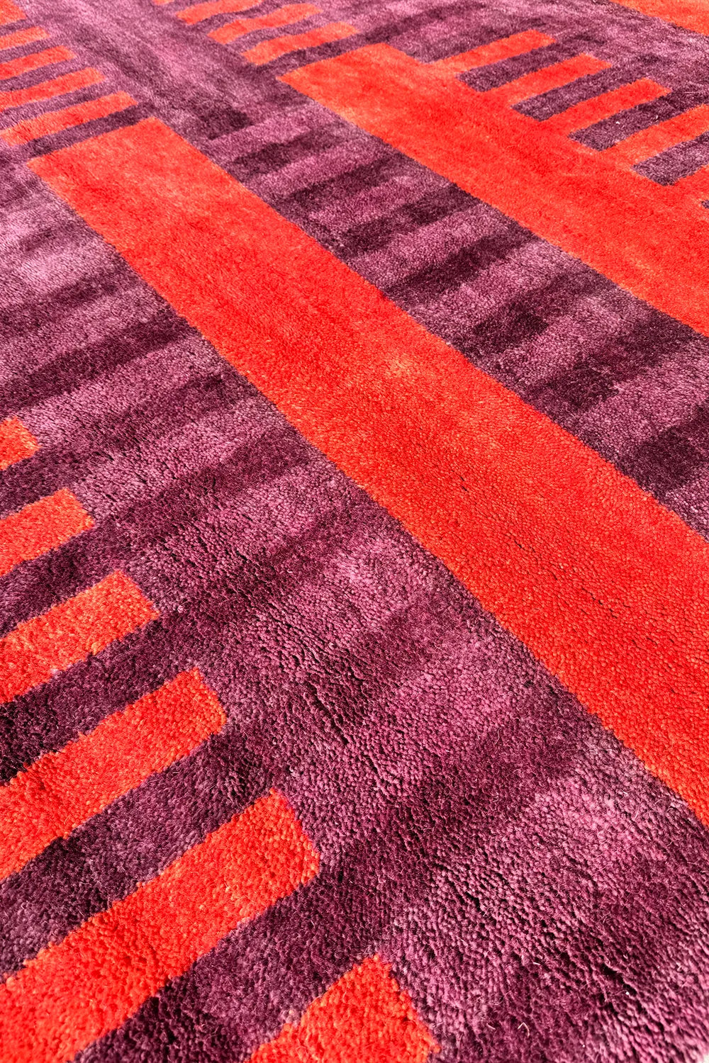 Vintage-inspired burgundy area rug with an abstract striped design, handwoven from wool